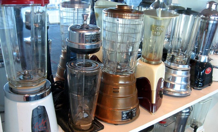 Variety of vintage electric blenders sit on a shelf