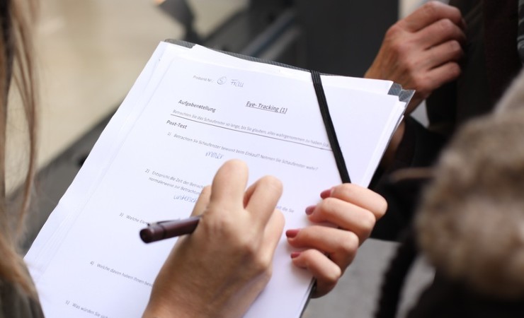 Researcher with clipboard taking notes on study participants